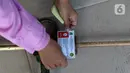Petugas UPT Disperindagkop UKM Kota Tangerang menempelkan stiker pada alat ukur timbangan saat sidak di Kecamatan Larangan, Kota Tangerang, Banten, Kamis (2/12/2021). Pengecekan dilakukan untuk memastikan alat ukur tersebut tidak ada kesalahan. (Liputan6.com/Angga Yuniar)