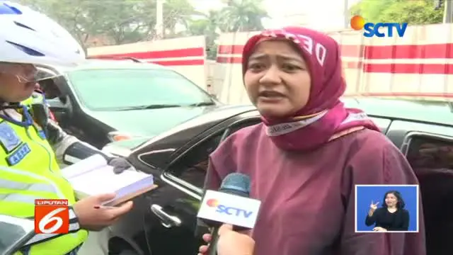 Perdebatan antara wanita pengendara mobil dengan plat nomor genap dengan Polantas di Simpang Pancoran, Jakarta Selatan, berlanjut hingga keluar kendaraan.