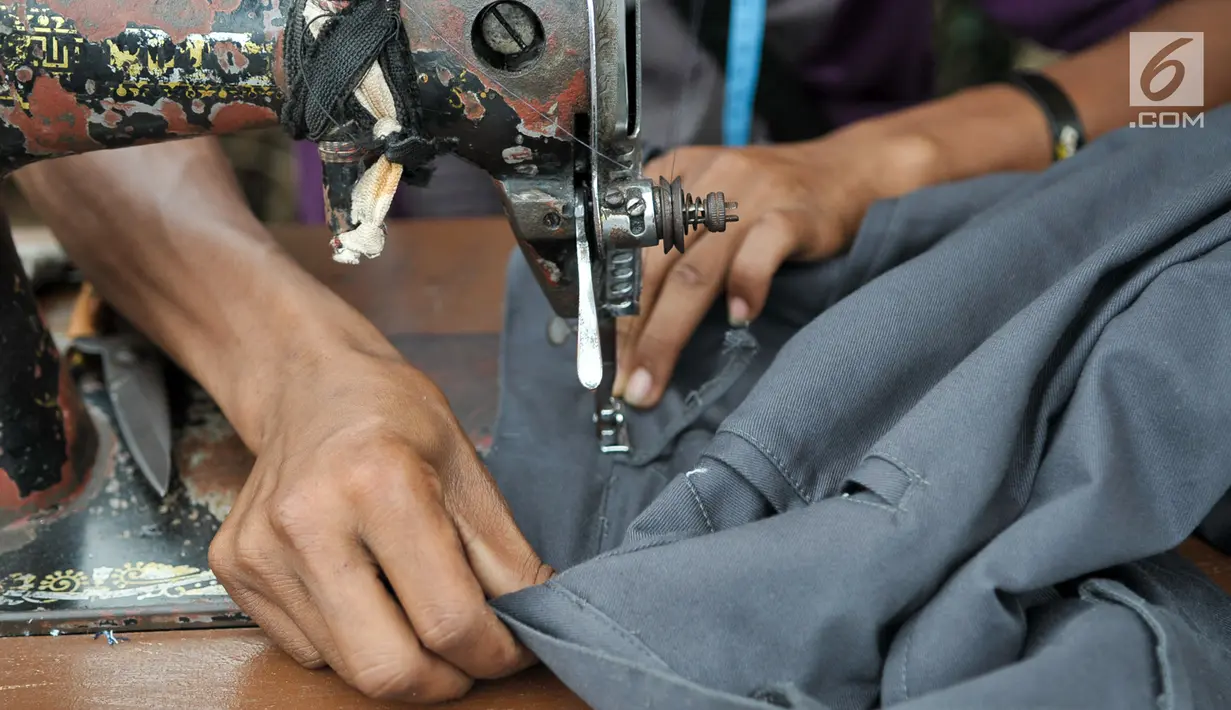 Menjelang hari raya Idul Fitri, penjahit vermak levis keliling mulai kebanjiran rezeki, Jakarta, Kamis (22/6). Para penjahit keliling mulai banyak menerima orderan warga untuk sekedar memotong atau mengecilkan pakaian. (Liputan6.com/Yoppy Renato)