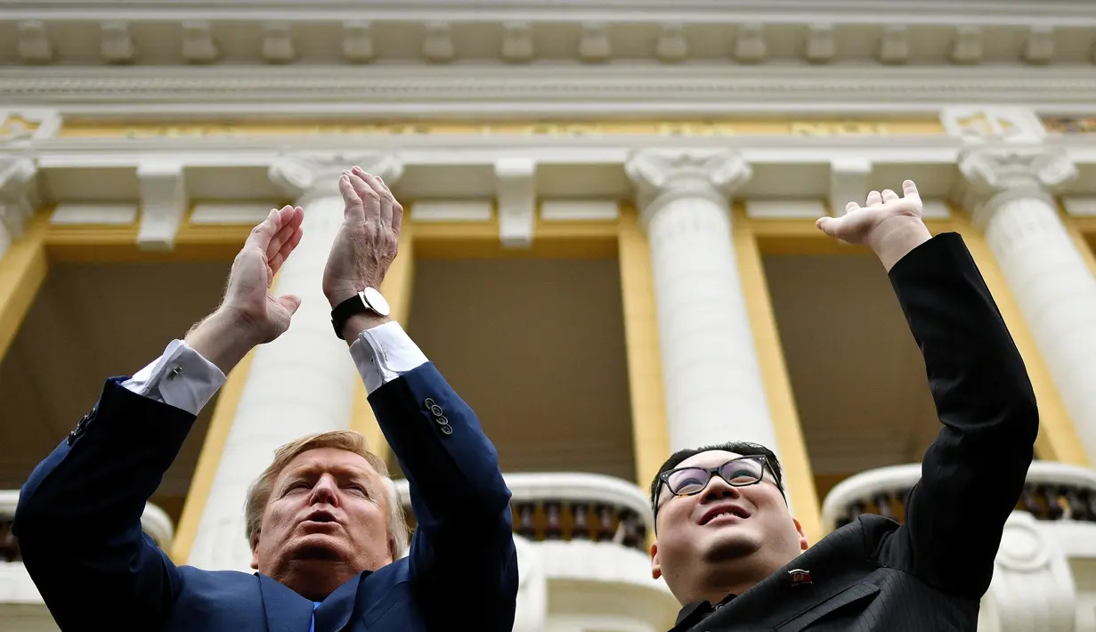 Peniru pemimpin Korut Kim Jong-un, Howard X dan peniru Presiden AS Donald Trump, Dennis Alan menyapa awak media di luar Gedung Opera, Vietnam  (22/2). Trump-Kim rencananya akan bertemu di Vietnam 27-28 Februari. (AFP Photo/Manan Vatsyayana)