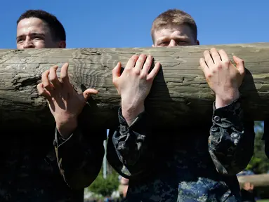 Kadet tahun pertama atau plebes menggotong kayu dalam Sea Trials di Akademi Angkatan Laut AS di Annapolis, Md., (16/5). Latihan ini merupakan penanda berakhirnya satu tahun pertama pendidikan militer mereka. (AP Photo/Patrick Semansky)