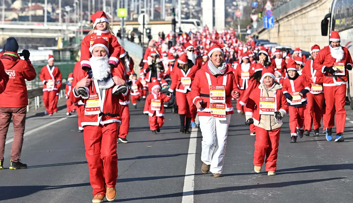 Orang-orang dengan kostum Sinterklas ikut serta dalam lomba lari tradisional menyambut Natal di tepi Sungai Danube di Budapest, Hungaria, pada tanggal 3 Desember 2023. (ATTILA KISBENEDEK/AFP)