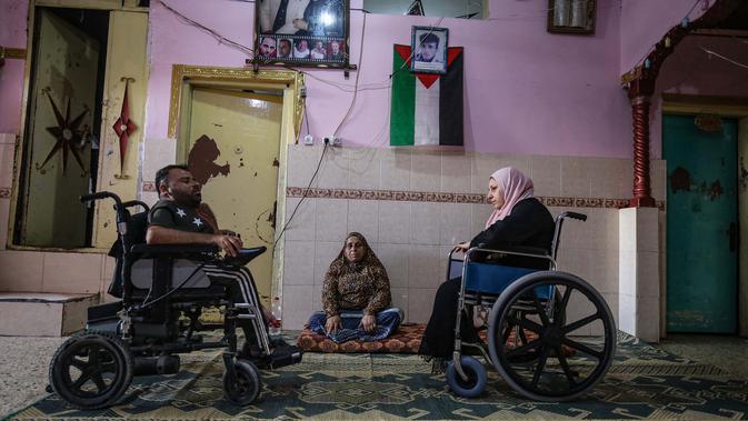 Nihad Jarboa (37) dan istrinya Zeinab (35), warga Palestina yang hidup dengan cacat fisik sejak masa kanak-kanak berada di rumah mereka di kamp pengungsi Rafah di Jalur Gaza selatan, pada 19 Juli 2020.  Suami dan istri tersebut tinggal dengan dua anaknya di rumah satu kamar. (AFP Photo/Said Khatib)