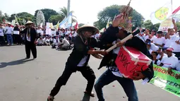 Petani tebu melakukan aksi tearikal saat unjuk rasa di depan Istana Merdeka, Jakarta, Senin (28/8). Aksi ini dilakukan lantaran dinilai belum ada upaya pemerintah membantu petani, khususnya harga gula lokal yang semakin rendah. (Liputan6.com/Angga Yuniar)