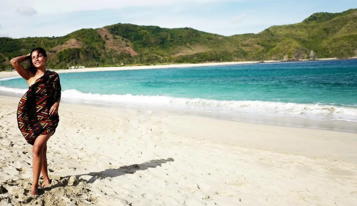 Tubuhnya dengan warna kulit sawo matang ini sangat dibanggakan Titi. Seperti di foto ini, nampaknya Titi hanya membalutkan tubuhnya dengan kain tenun bermotif etnik. (Instagram/titirajobintang)
