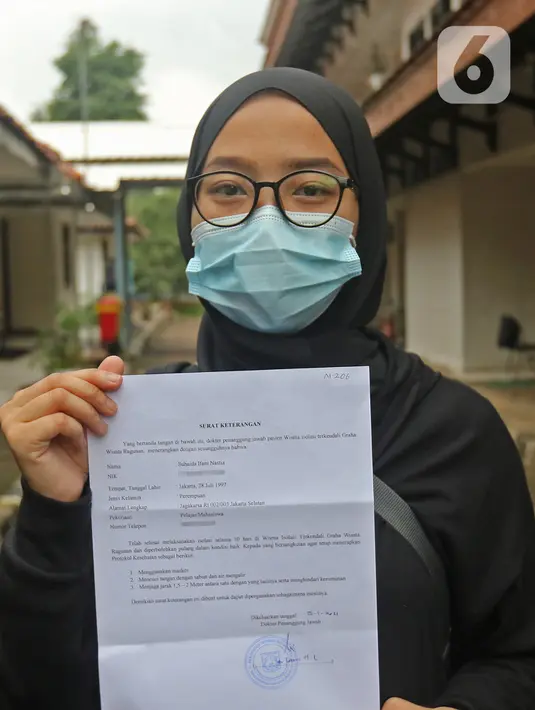 Pasien sembuh COVID-19 menunjukkan surat keterangan selesai isolasi di  Graha Wisata Ragunan di Jakarta, Jumat (29/1/2021). Data Satgas Covid-19 per Jumat (29/1), jumlah pasien yang sembuh bertambah 10.138 orang dengan total pasien sembuh mencapai 852.260 orang. (Liputan6.com/Herman Zakharia)