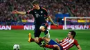 Penyerang Bayern Munchen, Thomas Muller (kiri) berusaha melewati bek Atletico Madrid, Stefan Savic di leg pertama liga champions di Vicente Calderon, Madrid, (28/4). Atletico menang atas Muenchen dengan skor 1-0. (Reuters/Sergio Perez)