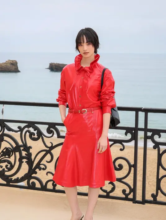  jaket suede beige dipadu kemeja merah bold dan celana tailored, dilengkapi tas Chanel pink statement yang playful sekaligus sentimental. [Dok/Chanel].