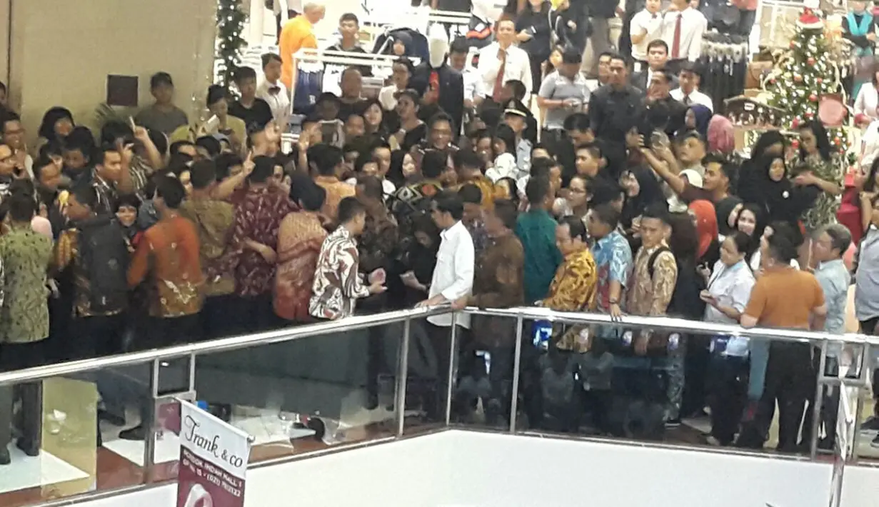 Presiden Joko Widodo dikerumuni pengunjung pusat perbelanjaan Pondok Indah Mall, Jakarta Selatan, Minggu (20/11). Kehadiran Jokowi yang dikawal sejumlah petugas Paspampres ini mengundang perhatian pengunjung mal. (Dok. Paspampres)