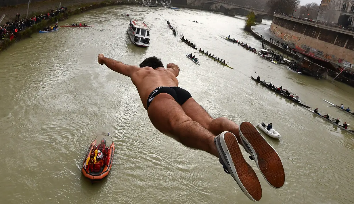Valter Schirra dari Italia melakukan terjun bebas ke sungai Tiber dari Jembatan Cavour di Roma, Selasa (1/1). Tradisi melompat dari jembatan setinggi 18 meter  dan menyelam ke sungai tersebut sebagai bentuk perayaan tahun baru. (Alberto PIZZOLI/AFP)