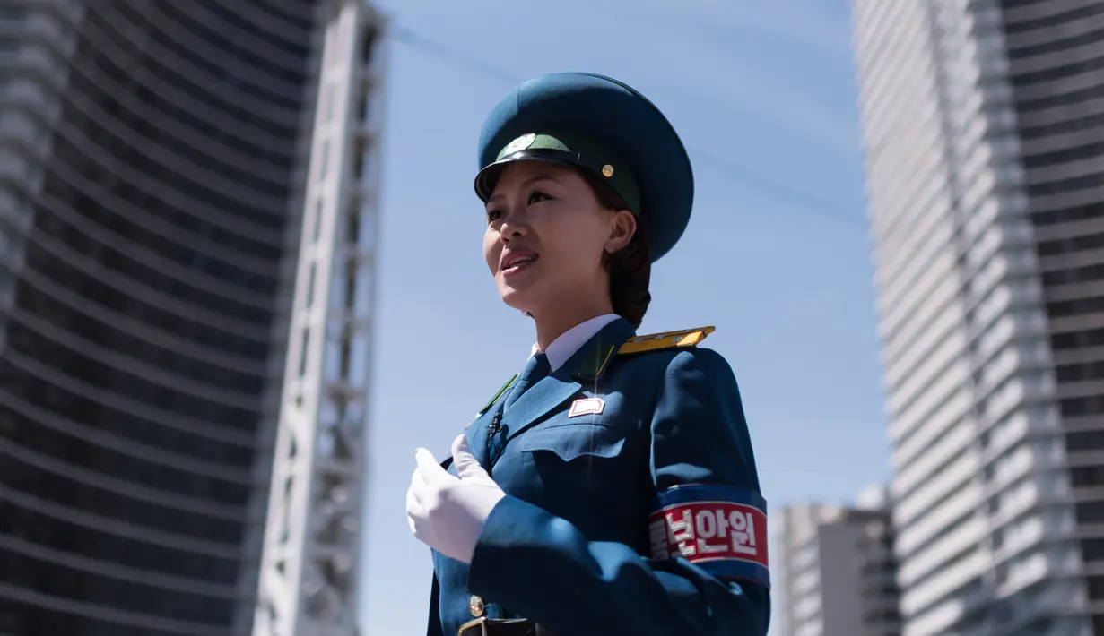 Seorang polisi wanita berada ditengah jalan untuk menagtur lalu lintas di Pyongyang, Korea Utara (5/6). Di Korea Utara menjadi polisi lalu lintas dipandang sebagai pekerjaan yang bergengsi. (AFP Photo/Ed Jones)