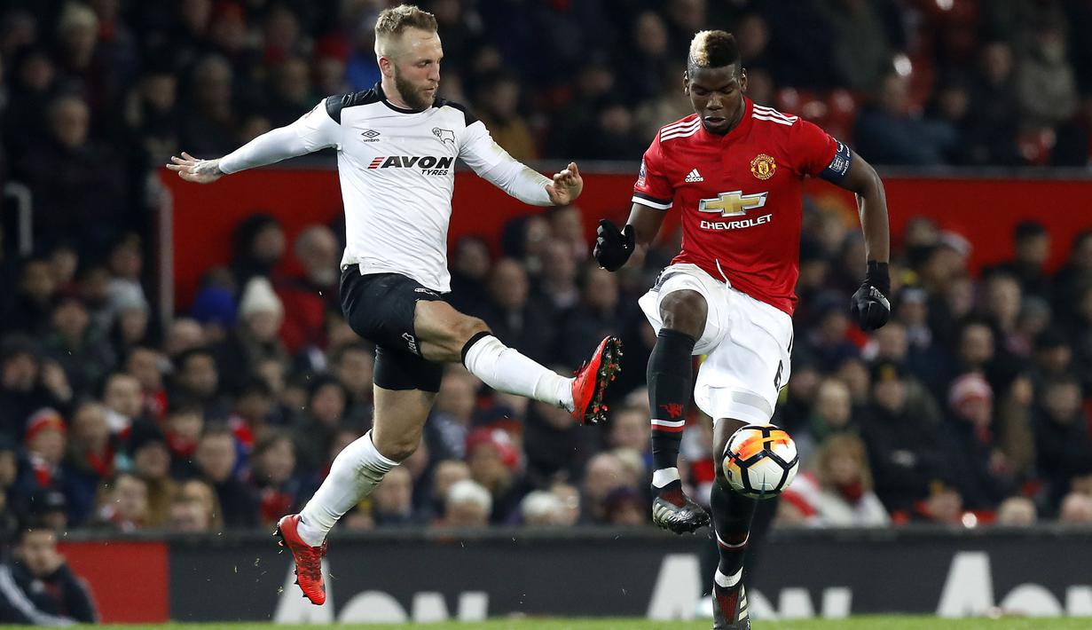 Pemain Manchester United, Paul Pogba (kanan) berusaha melewati adangan pemain Derby County, Johnny Russell pada laga PIala FA di Old Trafford, Manchester, (5/1/2018). Manchester United menang 2-0. (Martin Rickett/PA via AP)