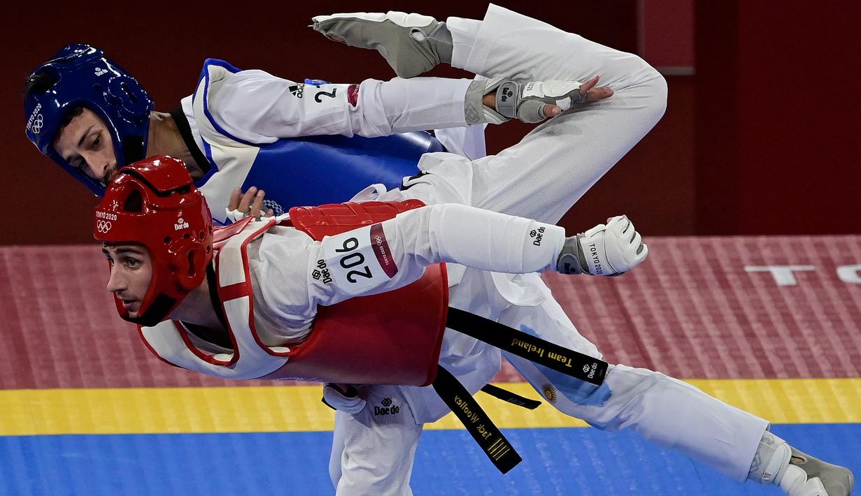 Lucas Lautaro Guzman dari Argentina (Biru) dan Jack Woolley dari Irlandia (Merah) bersaing dalam pertarungan babak penyisihan taekwondo putra -58kg selama Olimpiade Tokyo 2020 di Makuhari Messe Hall di Tokyo pada 24 Juli 2021. (AFP/Javier Soriano)