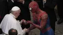 Paus Fransiskus bertemu Spider-Man, yang memberinya masker, pada akhir audiensi umum mingguan dengan jumlah umat terbatas di San Damaso Courtyard, Vatikan, Rabu (23/6/2021). Pria itu adalah Mattia Villardita (27) dari Italia utara yang menghibur anak-anak di rumah sakit. (AP Photo/Andrew Medichini)