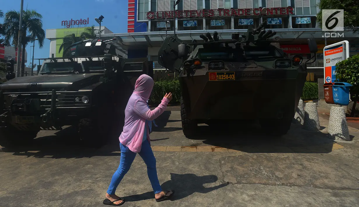 Pejalan kaki melintas di depan kendaraan lapis baja TNI di pertokoan Glodok, Jakarta, Jumat (11/5). Aksi Bela Palestina tersebut sebagai protes atas pemindahan Kedubes AS dari Tel Aviv di Israel ke kota Yerusalem di Palestina. (Merdeka.com/Imam Buhori)