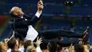 Pemain Real Madrid mengangkat pelatihnya, Zinedine Zidane, setelah meraih trofi Liga Champions ke-11 dalam final di Stadion San Siro, Milan, Minggu (29/5/2016) dini hari WIB. (Reuters/Kai Pfaffenbach)