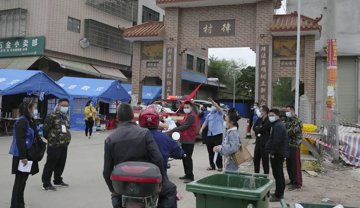 Petugas pemerintah mengontrol akses di pintu masuk desa Lu mengarah ke lokasi jatuhnya pesawat China Eastern di Guangxi, China barat daya, Selasa (23/3/2022). Insiden jatuhnya pesawat jenis Boeing 737-800 ini disebut bencana udara terburuk di China dalam hampir satu dekade. (AP Photo/Ng Han Guan)