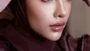 Ingin tampil sedikit lebih glamor di hari Lebaran? Ide makeup super cantik ala Aghnia Punjabi dengan glossy eyes dan lips bernuansa merah keunguan. [Foto: Instagram/emyaghnia]