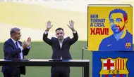 Pelatih baru Barcelona Xavi Hernandez (kanan) melambai ke penonton di sebelah presiden Barcelona Joan Laporta selama presentasi resminya di stadion Camp Nou, Spanyol, Senin (8/11/2021). Xavi dikontrak selama dua tahun sampai Juni 2023 mendatang. (AP Photo/Joan Monfort)