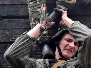 Tentara Kementerian Dalam Negeri Belarus ikut serta dalam ujian kualifikasi memperoleh 'Madder Beret' di desa Volovshchina, Minsk, Selasa (23/10). Madder Beret, simbol bergengsi atas pencapaian tertinggi dalam pelatihan tempur Belarus. (Sergei GAPON/AFP)