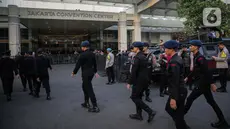 Sejumlah petugas pengamanan KPU dan kepolisian serta TNI berjaga di depan area debat kedua Capres-Cawapres 2024 di Jakarta Convention Center, Jumat (22/12/2023). (Liputan6.com/Faizal Fanani)