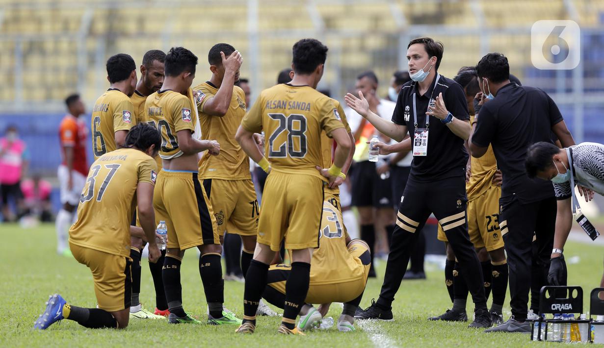 Pelatih Bhayangkara Solo FC Paul Christopher Munster memberikan instruksi kepada pemainnya saat water break melawan Borneo FC Samarinda dalam pertandingan babak penyisihan Piala Menpora 2021 di Stadion Kanjuruhan, Malang, Jawa Timur, Senin (22/3/2021). (Bola.com/Arief Bagus)