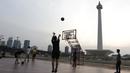 Sejumlah warga bermain basket di kawasan Monas, Jakarta, Jumat (11/10). Kawasan Monas menjadi pilihan warga Jakarta dan pekerja ibu kota untuk berolahraga sore. (Bola.com/Yoppy Renato)