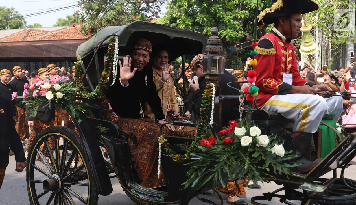 Presiden Jokowi dan Ibu Negara, Iriana berada di kereta kencana menuju Graha Saba Buana, Solo, Rabu (8/11). Pernikahan putri presiden Jokowi, Kahiyang Ayu dengan Bobby Nasution diiringi prosesi kirab kereta kencana. (Liputan6.com/Angga Yuniar)