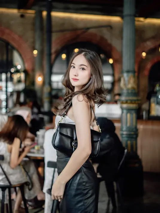 Potret cantik Laura Moane dengan atasan tanpa lengan dipadu celana kulit berwarna hitam, dan shoulder bag yang juga berwarna hitam. [Foto: Instagram/its_lauramoane2]