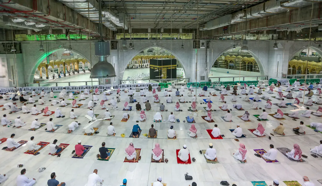 DIBUKA KEMBALI SALAT BERJEMAAH DI MASJIDIL HARAM: Warga Saudi dan ekspatriat melakukan sholat "Al Fajr" di Masjidil Haram, Mekkah (18/10/2020). Arab Saudi akhirnya mengizinkan warganya salat di Masjidil Haram untuk pertama kalinya sejak pandemi Covid-19. (AFP/STR)