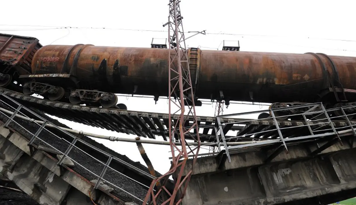 Serangkaian kereta barang masih terjebak di atas jembatan yang runtuh di dekat desa Novobakhmutivka, 30 km sebelah utara Donetsk, Ukraina, (8/7/2014). (AFP PHOTO/Dominique Faget)