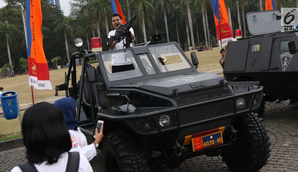 Warga bergaya di atas kendaraan taktis TNI pada pameran Alat Utama Sistem Persenjataan TNI di Kawasan Monas, Jakarta, Kamis (27/9). Pameran ini bagian perayaan HUT TNI ke-73. (Liputan6.com/Helmi Fithriansyah)