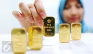 Pegawai menunjukan emas batangan di Jakarta, Senin (10/10). Di awal pekan ini, harga emas PT Aneka Tambang Tbk (ANTAM) tetap bertahan di Rp 599 ribu per gram. (Liputan6.com/Angga Yuniar)