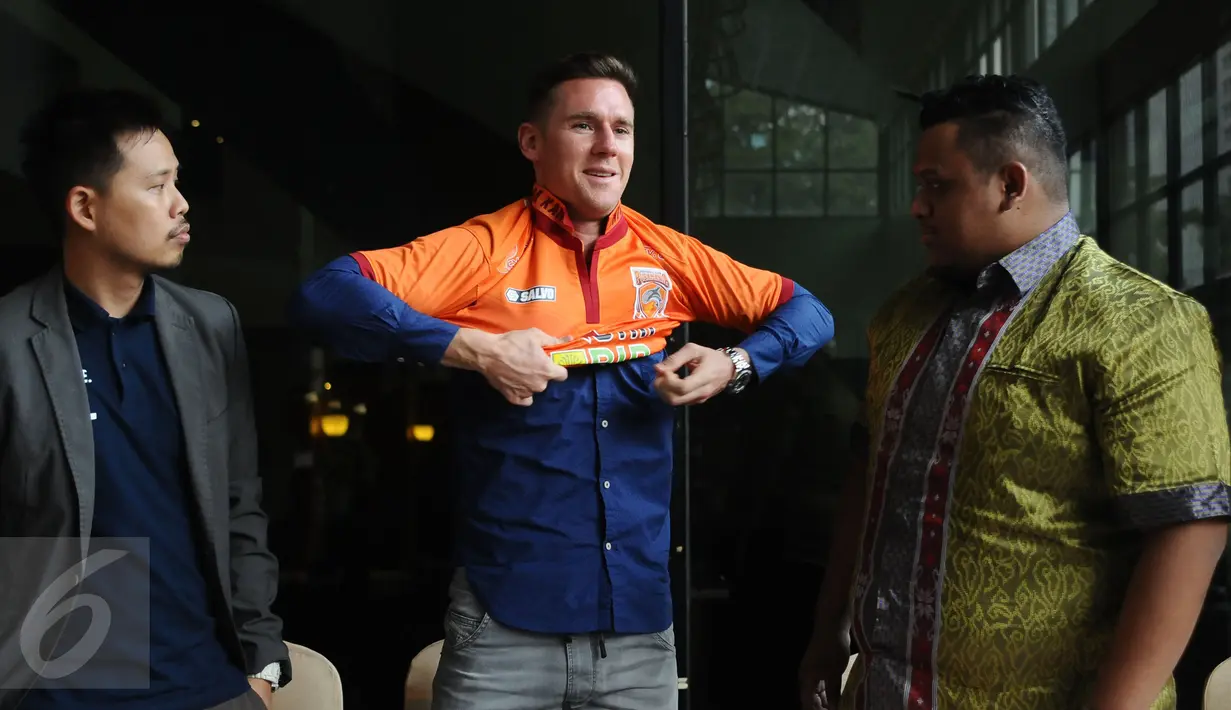 Shane Smeltz (tengah) memakai kaus tim PBFC usai penandatanganan kontrak di Jakarta, Selasa (11/4). Shane Smeltz berstatus marquee player dan diikat kontrak oleh PBFC selama semusim. (Liputan6.com/Helmi Fithriansyah)