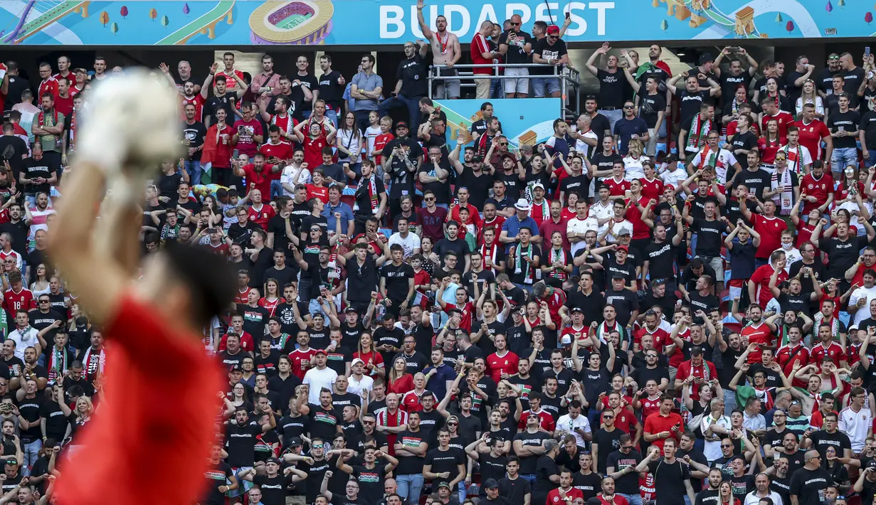 Penggemar sepak bola menghadiri pertandingan grup F Euro 2020 antara Hungaria vs Portugal di stadion Ferenc Puskas di Budapest, Selasa (15/6/2021). Pertandingan yang dimenangkan oleh Portugal 3-0 itu dihadiri lebih dari 60.000 penonton atau kapasitas maksimal Stadion. (Bernadett Szabo/Pool via AP)