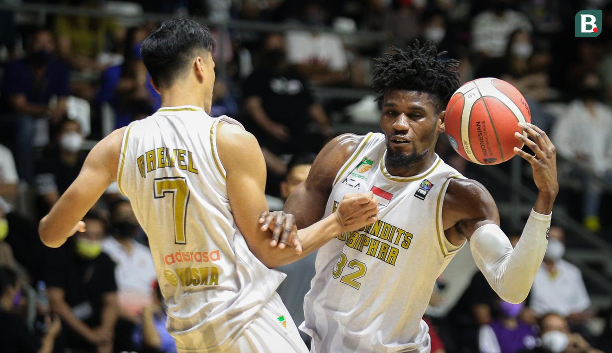Pemain West Bandits Combiphar Solo, D. Harris (kanan) bertabrakan dengan G. Risky saat laga pekan pertama IBL Tokopedia 2022 melawan Rans PIK Basketball di Hall Basket Gelora Bung Karno, Senayan, Sabtu (15/01/2022). (Bola.com/Bagaskara Lazuardi)