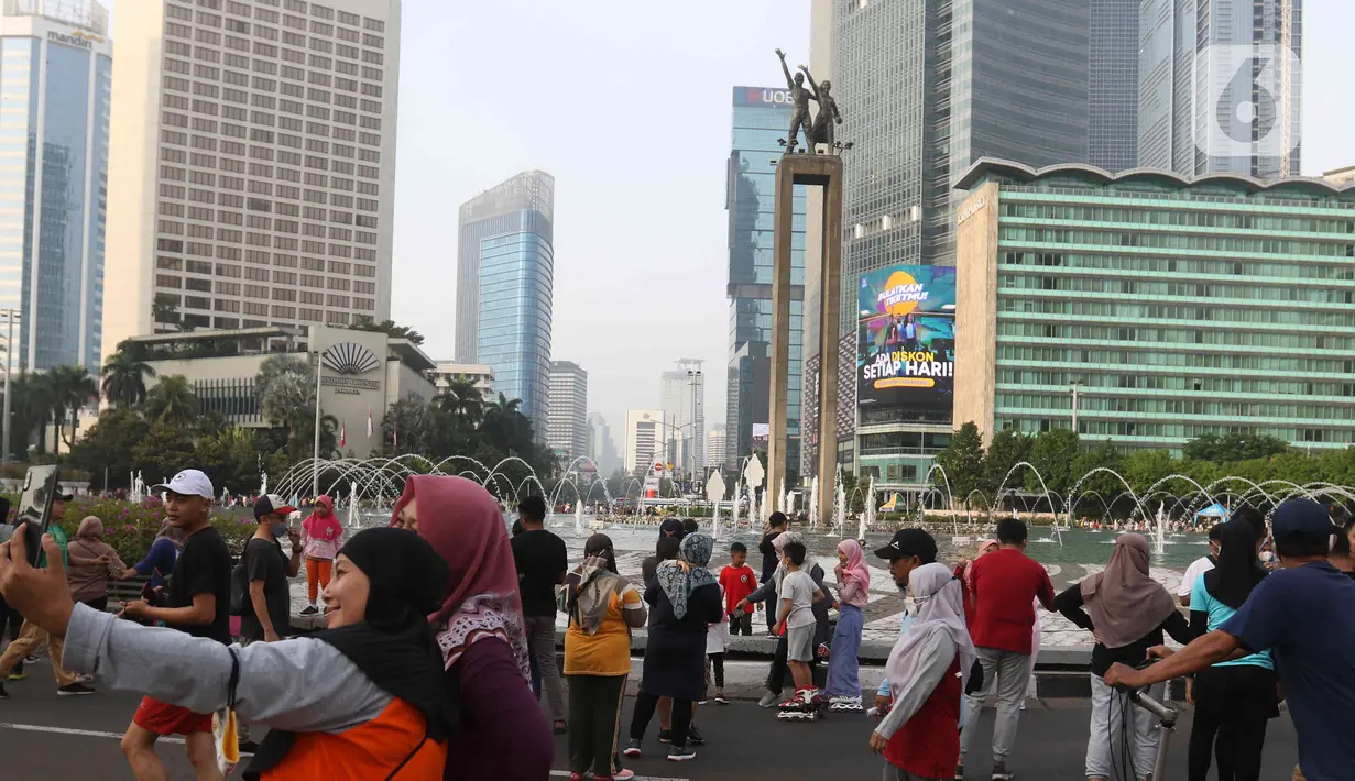 Warga berswafoto di kawasan bundaran HI, Jakarta, Minggu (12/6/2022). Car Free Day di kawasan Sudirman-Thamrin dimanfaatkan warga untuk berolah raga dan ber foto-foto. (Liputan6.com/Herman Zakharia)
