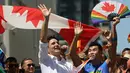 Perdana Menteri Kanada Justin Trudeau melambaikan tangan saat mengikuti pawai LGBT Toronto's Pride Parade di Toronto, Kanada, Minggu (23/6/2019). Pawai digelar untuk mengenang peristiwa Stonewall yang terjadi di New York pada Juni 1969. (Chris Young/The Canadian Press via AP)