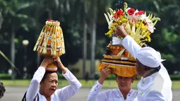 Umat Hindu menyalakan dupa di atas sesajen saat persiapan upacara Tawur Agung Kesanga di Silang Monas, Jakarta, Jumat (20/3/2015). Upacara tersebut untuk membersihkan jagat raya sebelum pelaksanaan Nyepi esok harinya. (Liputan6.com/Faizal Fanani)