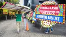 Sejumlah petugas membawa karangan bunga di kantor PSSI yang terletak di GBK Arena, Senayan, Jakarta, Kamis (30/03/2023) sebagai respon pembatalan Indonesia sebagai tuan rumah Piala Dunia U-20 2023 oleh FIFA. (Bola.com/Bagaskara Lazuardi)