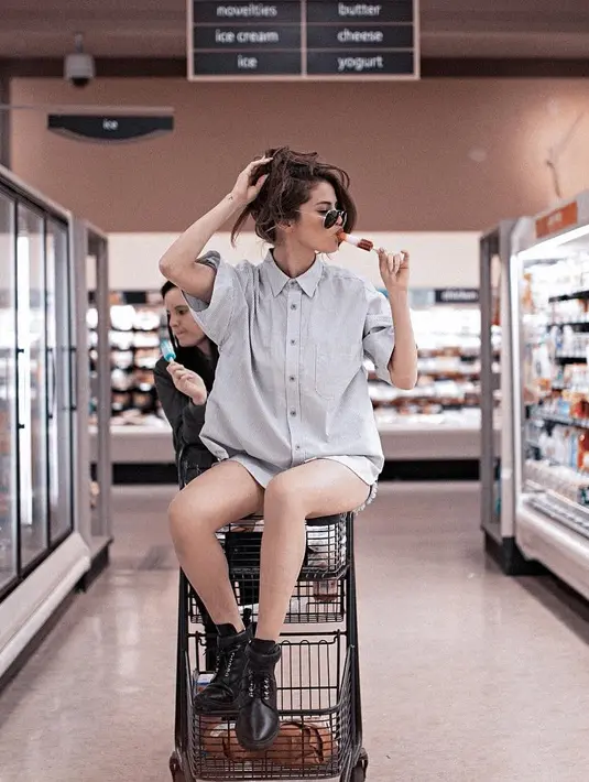Edgy banget! Selena memakai kemeja dengan paduan short pantsnya. Tampilannya saat berkunjung ke supermarket makin kece dengan boots hitam yang dipakainya. (Instagram/selenagomez)