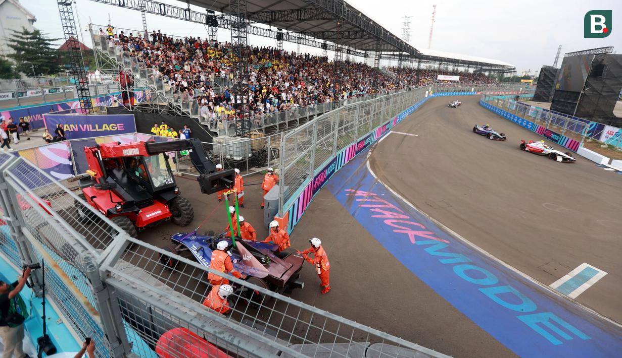 Sejumlah petugas sedang mengevakuasi mobil dari pembalap Team Maserati MSG Racing, Stoffel Vandoorne saat ajang Jakarta E-Prix 2025 yang berlangsung di Jakarta International ePrix Circuit, Ancol, Sabtu (21/6/2025). (Bola.com/M Iqbal Ichsan)