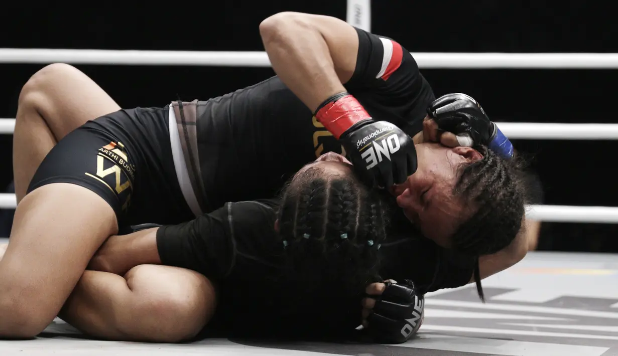 Petarung Indonesia, Priscilla Lumban Gaol, mengunci petarung Kamboja, Nou Srey Pov, pada laga ONE Championship di Istora Senayan, Jakarta, Jumat (3/5). Priscilla menang mutlak atas lawannya. (Bola.com/Yoppy Renato)