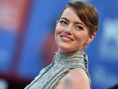 Aktris Emma Stone tersenyum saat tiba menghadiri pembukaan Festival Film Venice ke-73 di Italia, (31/8). Menggunakan gaun metalik dari Atelier Versace Emma terlihat cantik dan memukau. (AFP Photo/TIZIANA FABI)