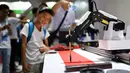 Lengan robot mendemonstrasikan pembuatan kaligrafi dalam Konferensi Robot Dunia 2019 di Beijing, China, Selasa (20/8/2019). (WANG Zhao/AFP)