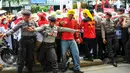 Personel kepolisian berusaha menahan para bidan desa yang berupaya menutup akses jalan saat demonstrasi di depan gedung Kemenkes, Jakarta, Rabu (4/5). Para bidan menuntut diangkat menjadi pegawai tetap tanpa syarat.  (Liputan6.com/Yoppy Renato)
