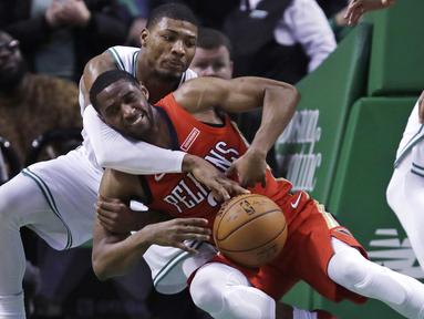 Aksi pemain Boston Celtics, Marcus Smart (kiri) berebut bola dengan pemain New Orleans Pelicans, Ian Clark (2) pada laga NBA basketball game di TD Garden, Boston, (16/1/2018). Celtics kalah 113-116. (AP/Charles Krupa)