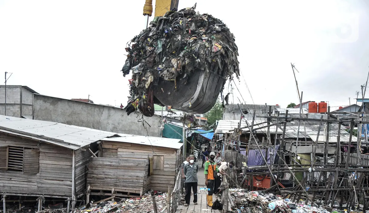 Pekerja Suku Dinas Lingkungan Hidup Kepulauan Seribu menggunakan alat berat saat membersihkan sampah di kawasan Kali Baru, Cilincing, Jakarta Utara, Rabu (23/2/2022). Mulai hari ini, lautan sampah tersebut dibersihkan oleh petugas terkait setelah ramai diberitakan. (merdeka.com/Iqbal S. Nugroho)