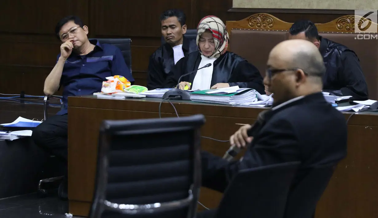 Terdakwa dugaan menghalangi proses penyidikan KPK terhadap Eddy Sindoro, Lucas (kiri) menyimak keterangan Novel Baswedan saat sidang lanjutan di Pengadilan Tipikor Jakarta, Kamis (10/1). Sidang mendengar keterangan saksi. (Liputan6.com/Helmi Fithriansyah)