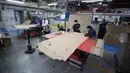 Pekerja sebuah perusahaan mendesain kardus yang dapat berfungsi sebagai tempat tidur rumah sakit dan peti mati untuk pasien COVID-19 di Bogota, Kolombia, Jumat (8/5/2020). Perusahaan ini menanggapi kekurangan tempat tidur dan peti mati selama pandemi virus corona.  (AP/Fernando Vergara)